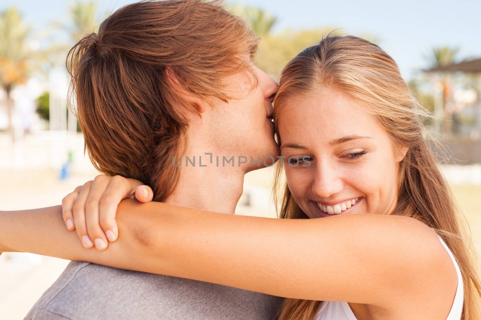 Young beautiful couple closeup portrait at the beach on sunny day