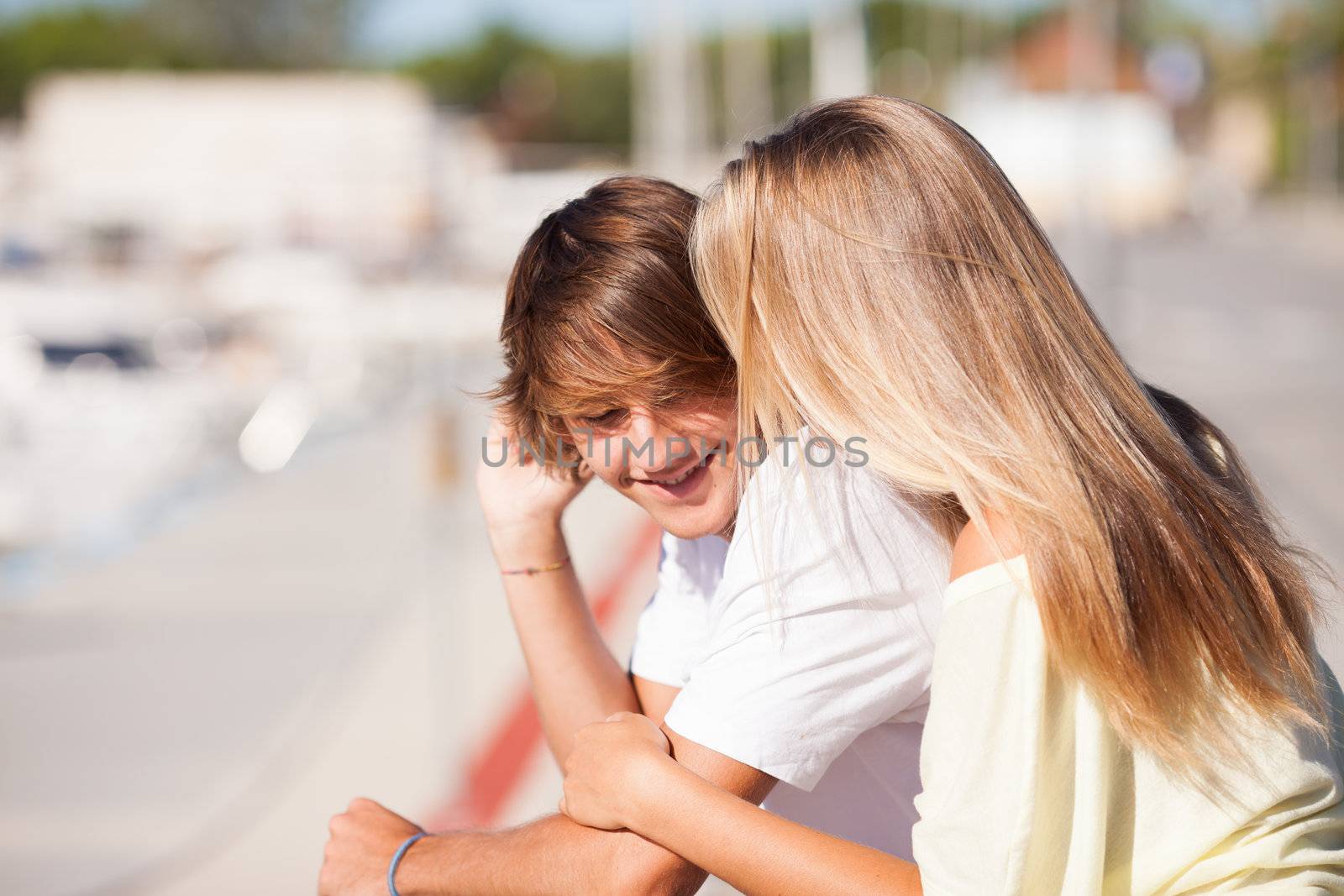 Young beautiful couple enjoying a walk by the harbour