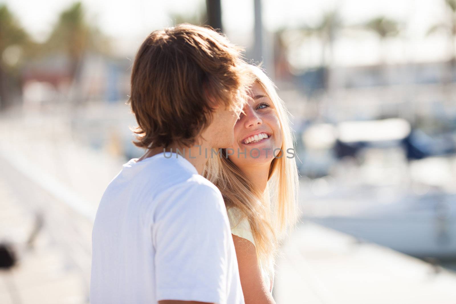 Young beautiful couple enjoying a walk by the harbour