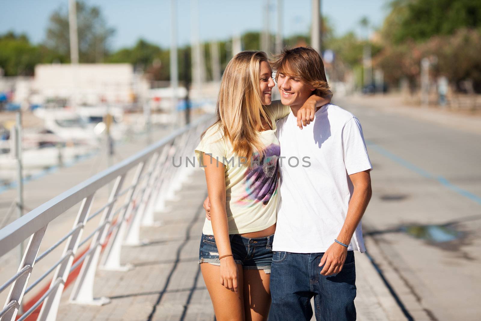 Young beautiful couple enjoying a walk by the harbour