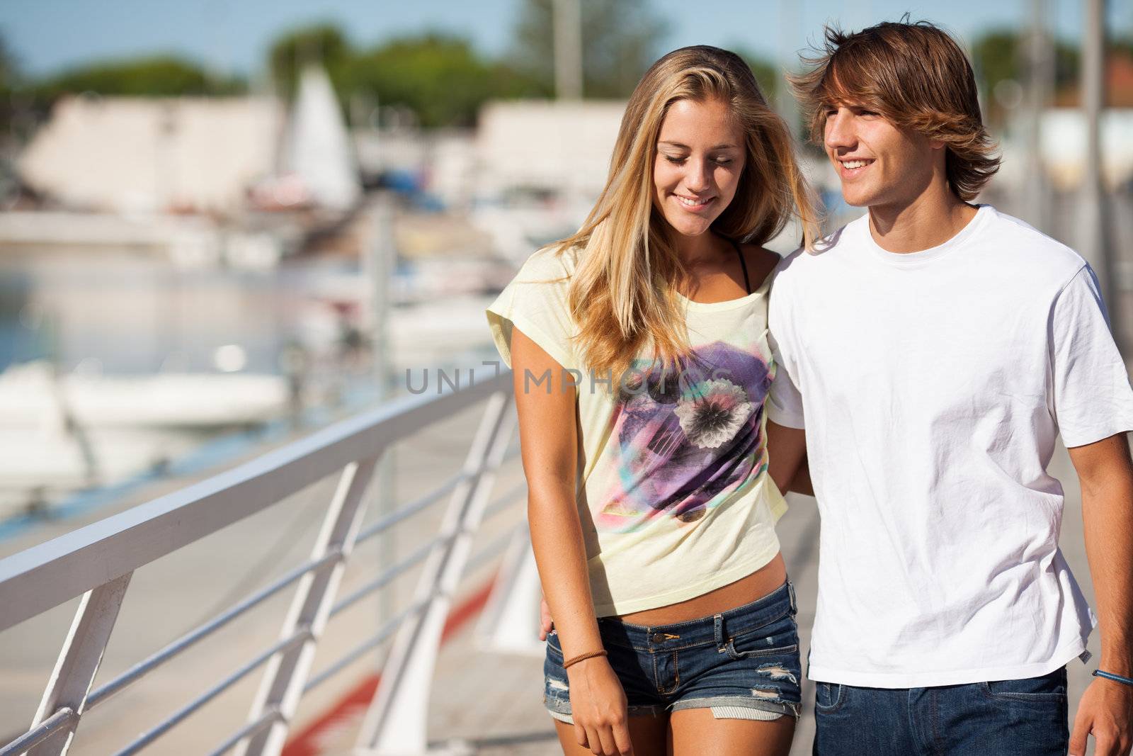 Young beautiful couple enjoying a walk by the harbour