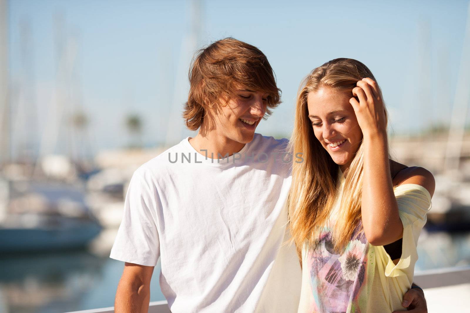 Young beautiful couple enjoying a walk by the harbour