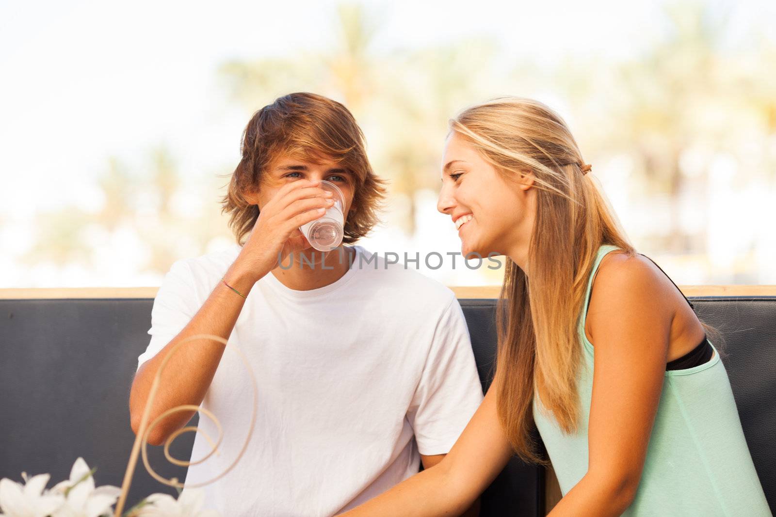 Young beautiful couple having fun in a beach bar