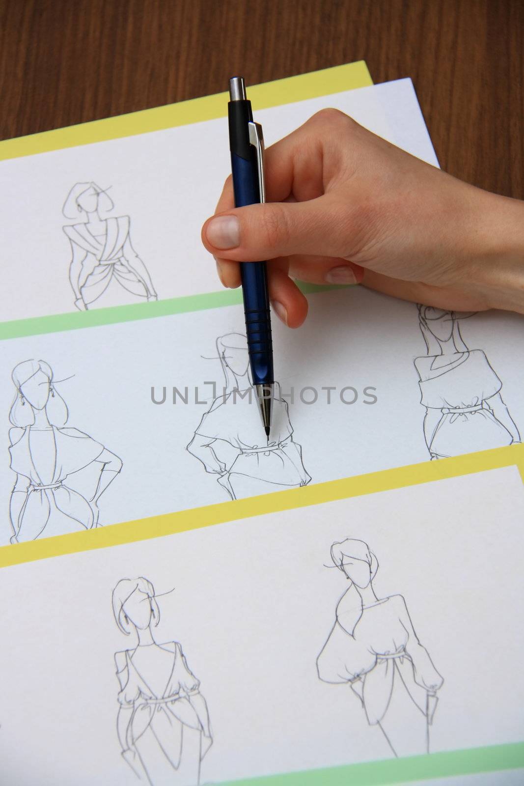 designer assessing fashion drawings on the collection of clothes