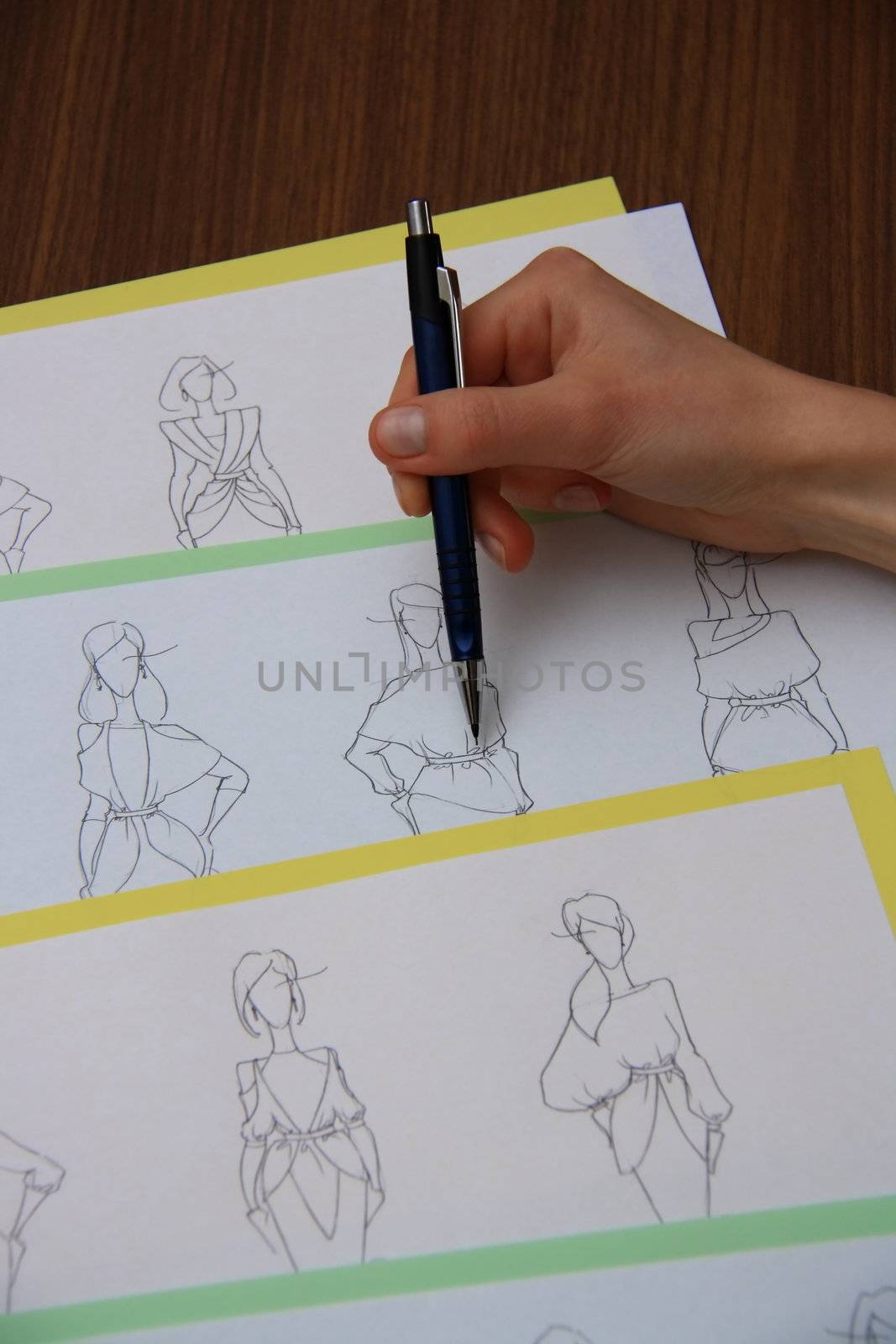 designer assessing fashion drawings on the collection of clothes