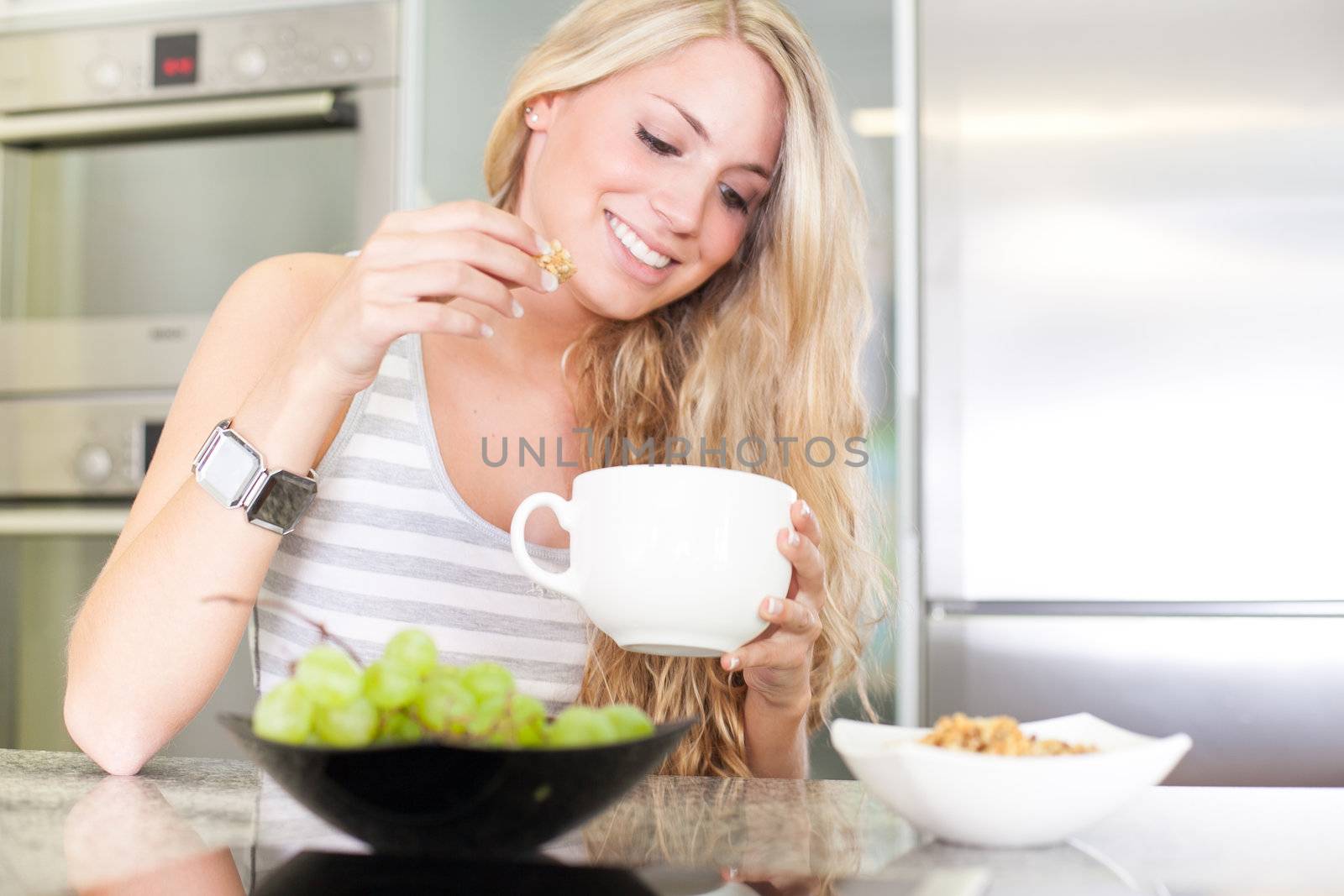 Young beautiful woman enjoying healthy breakfast in the kitchen by Lcrespi