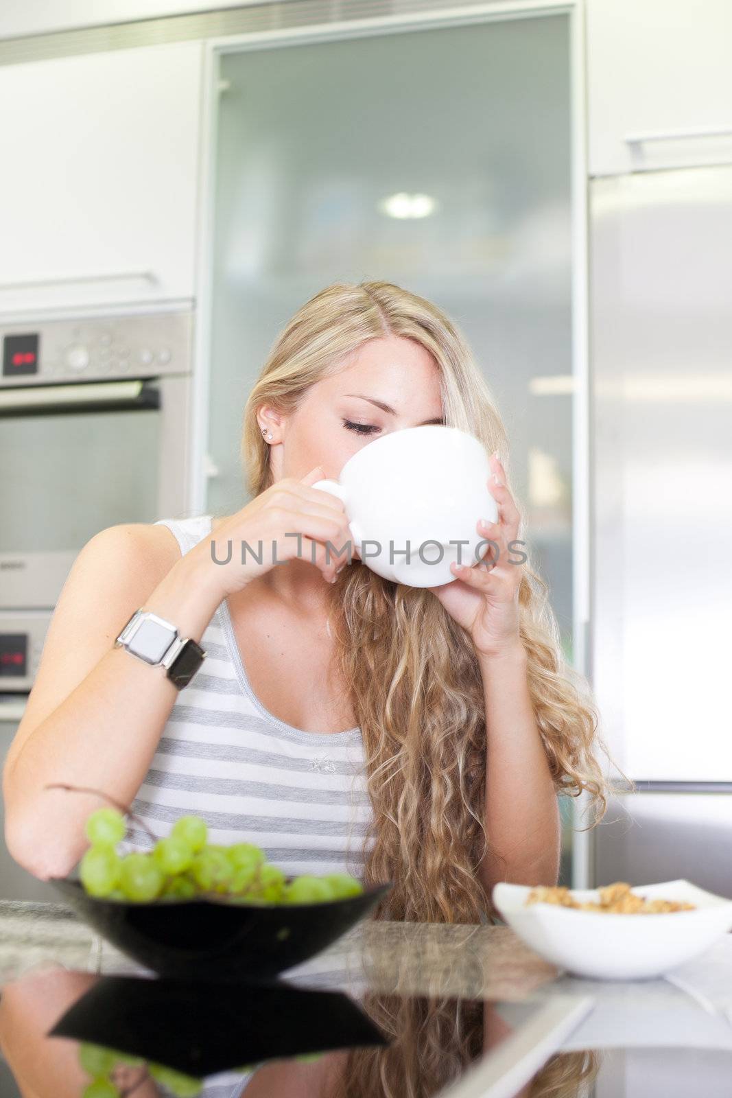 Young beautiful woman having a healthy breakfast in the kitchen