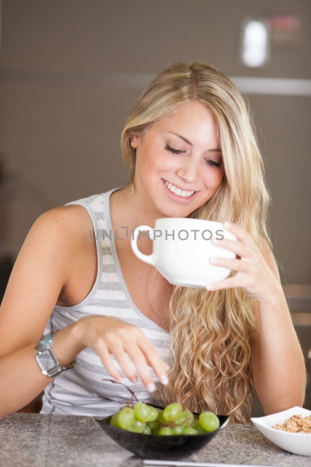 Young beautiful woman having a healthy breakfast in the kitchen