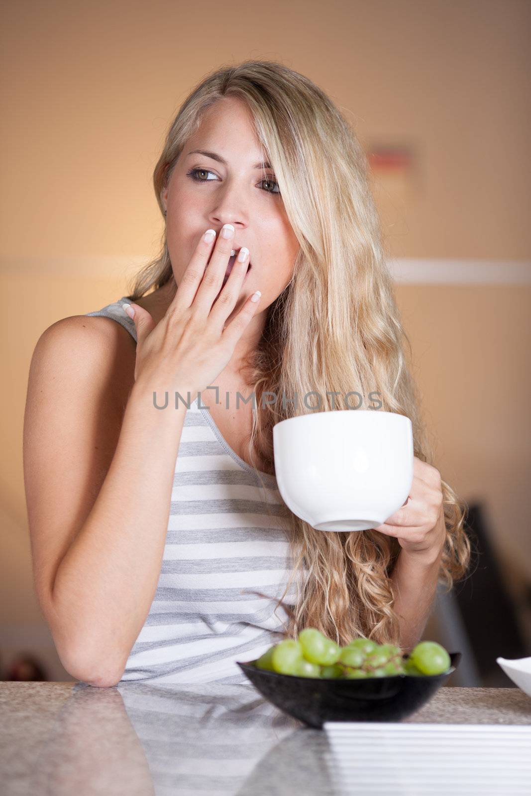 Young beautiful woman having a healthy breakfast in the kitchen