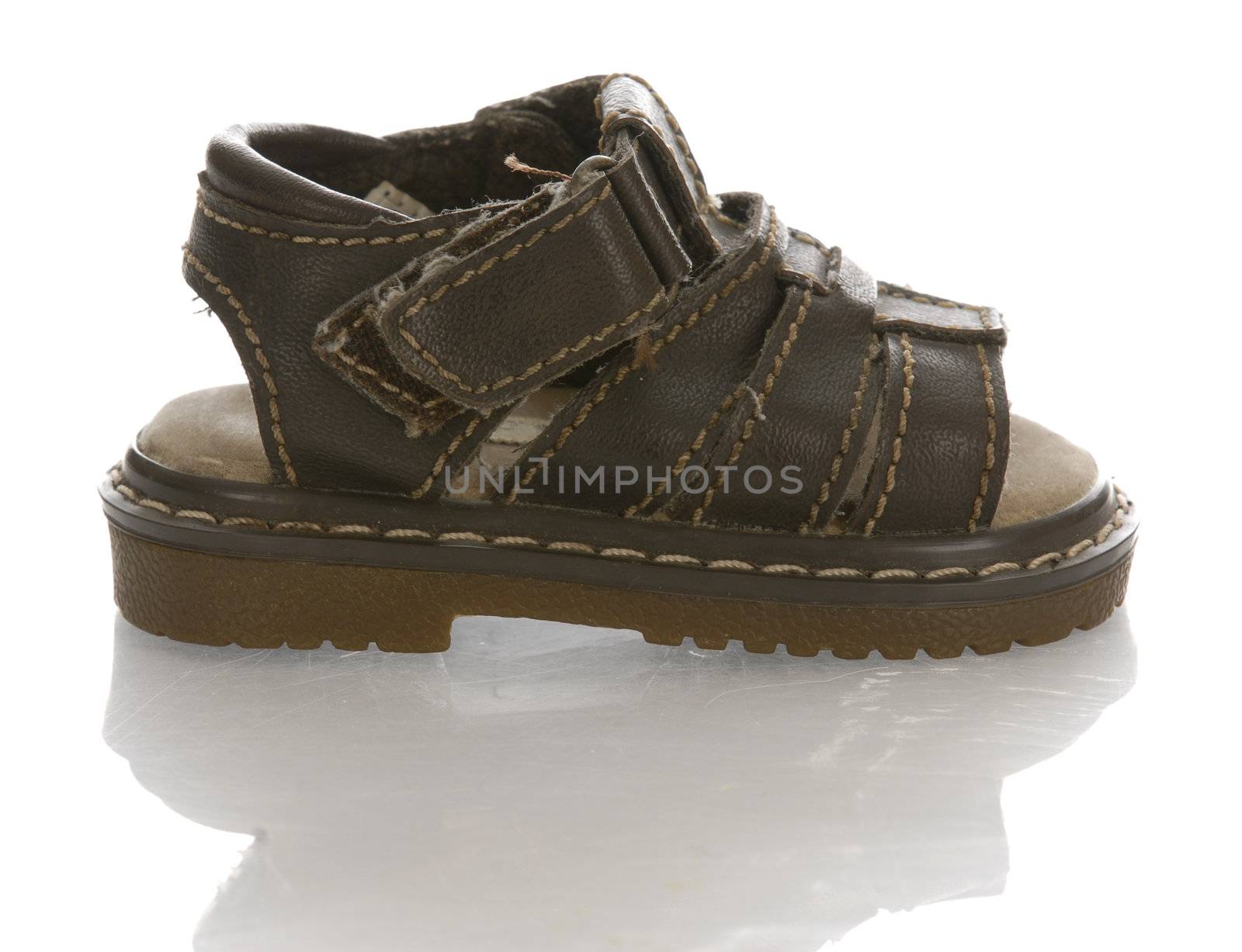 leather infant or baby sandal with reflection on white background