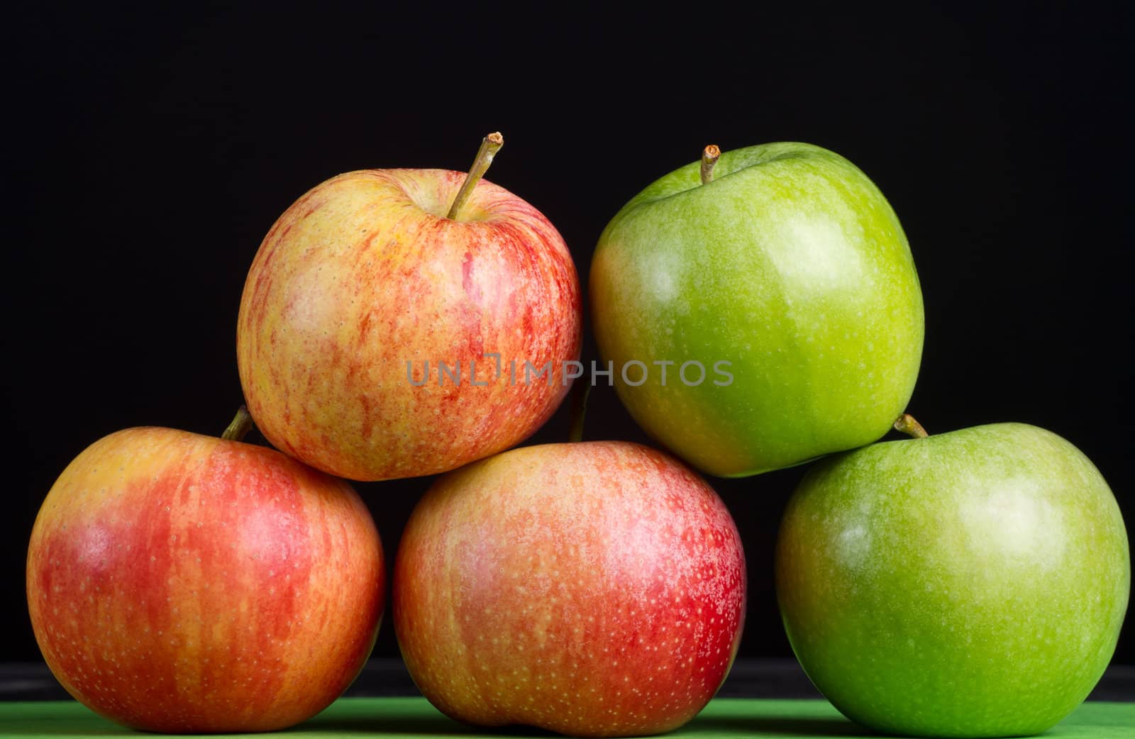 Apples in a row on black backround