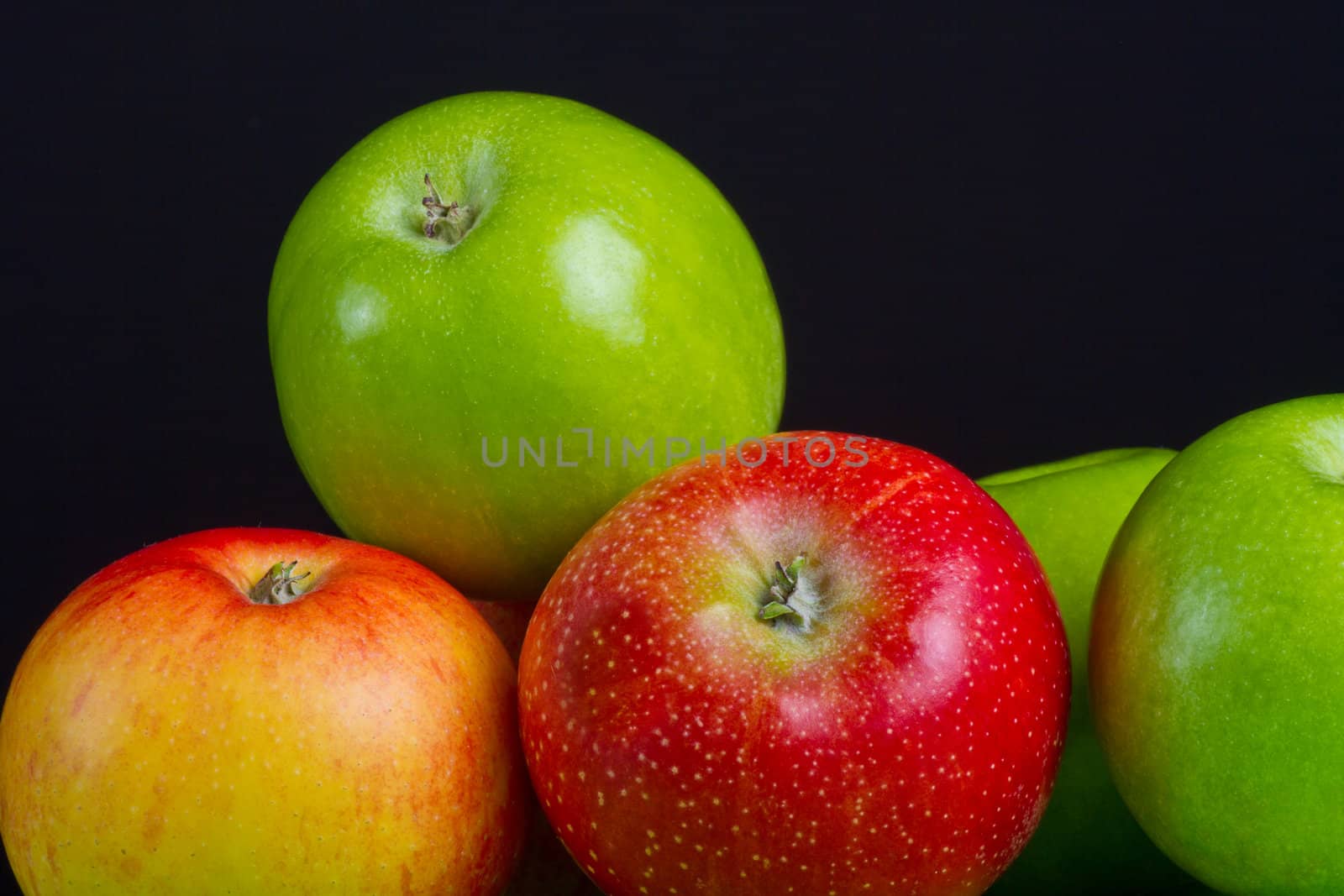 Apples in a row on black backround