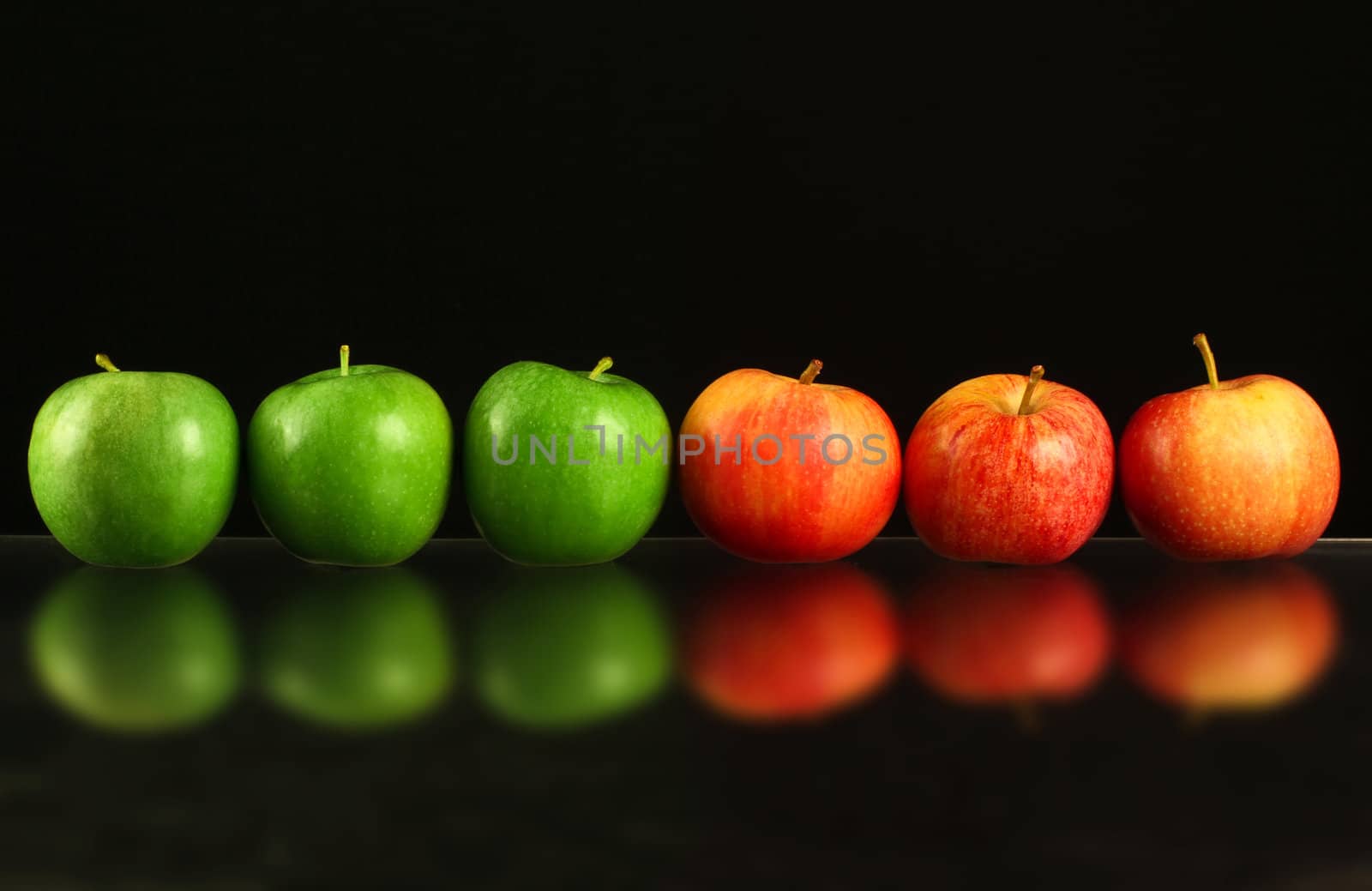 Apples in a row on black backround