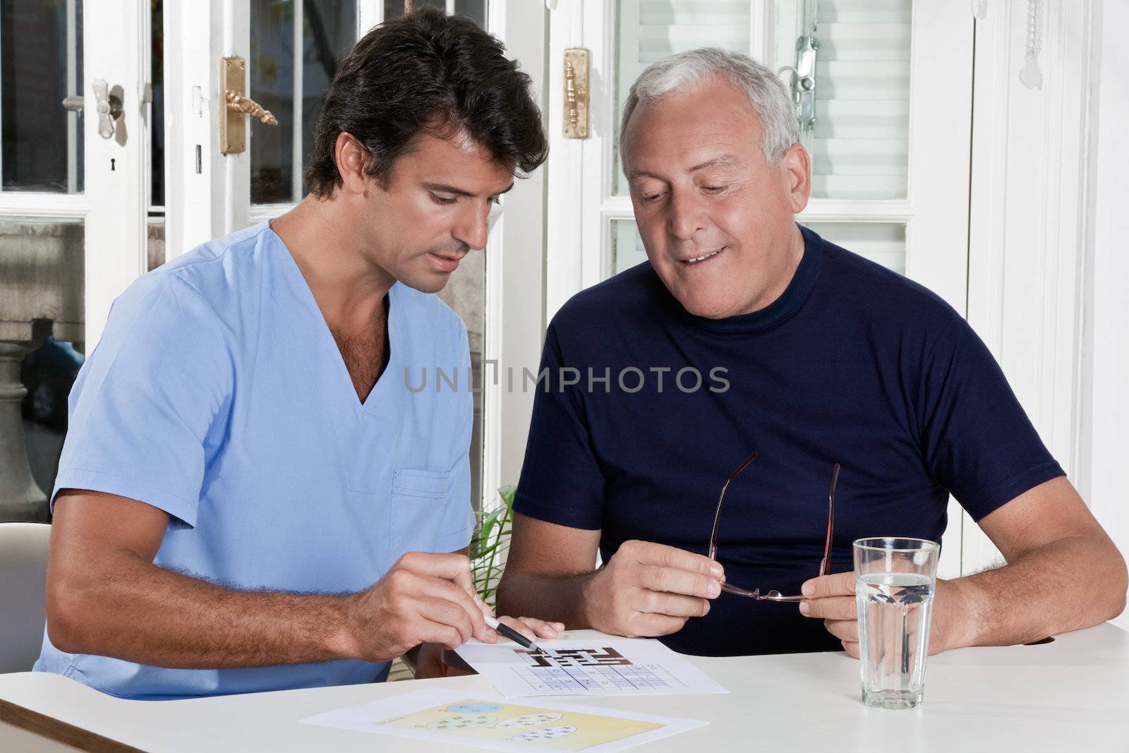 Mature Man playing Sudoku Puzzle by leaf