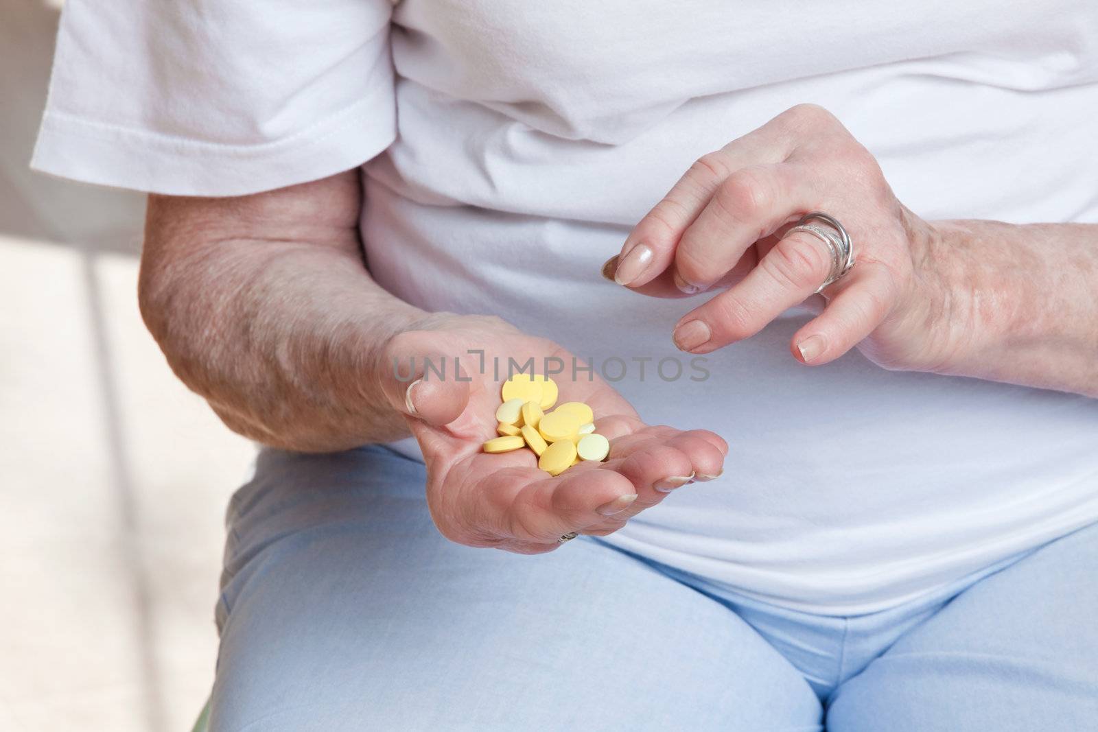 Sick senior woman holding her pills.