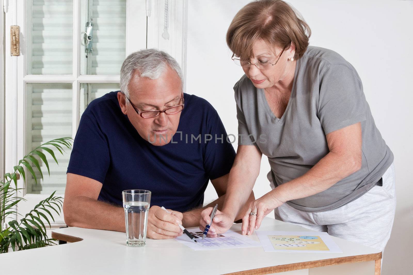 Mature Couple playing Scrabble Game by leaf