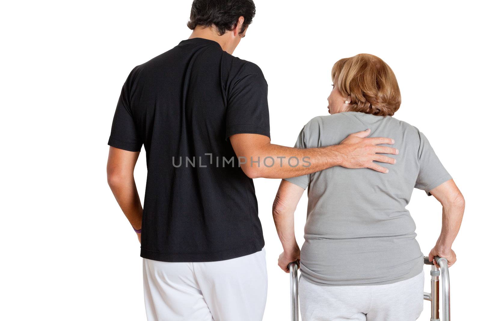 Rear view of trainer assisting senior woman with her walker over white background