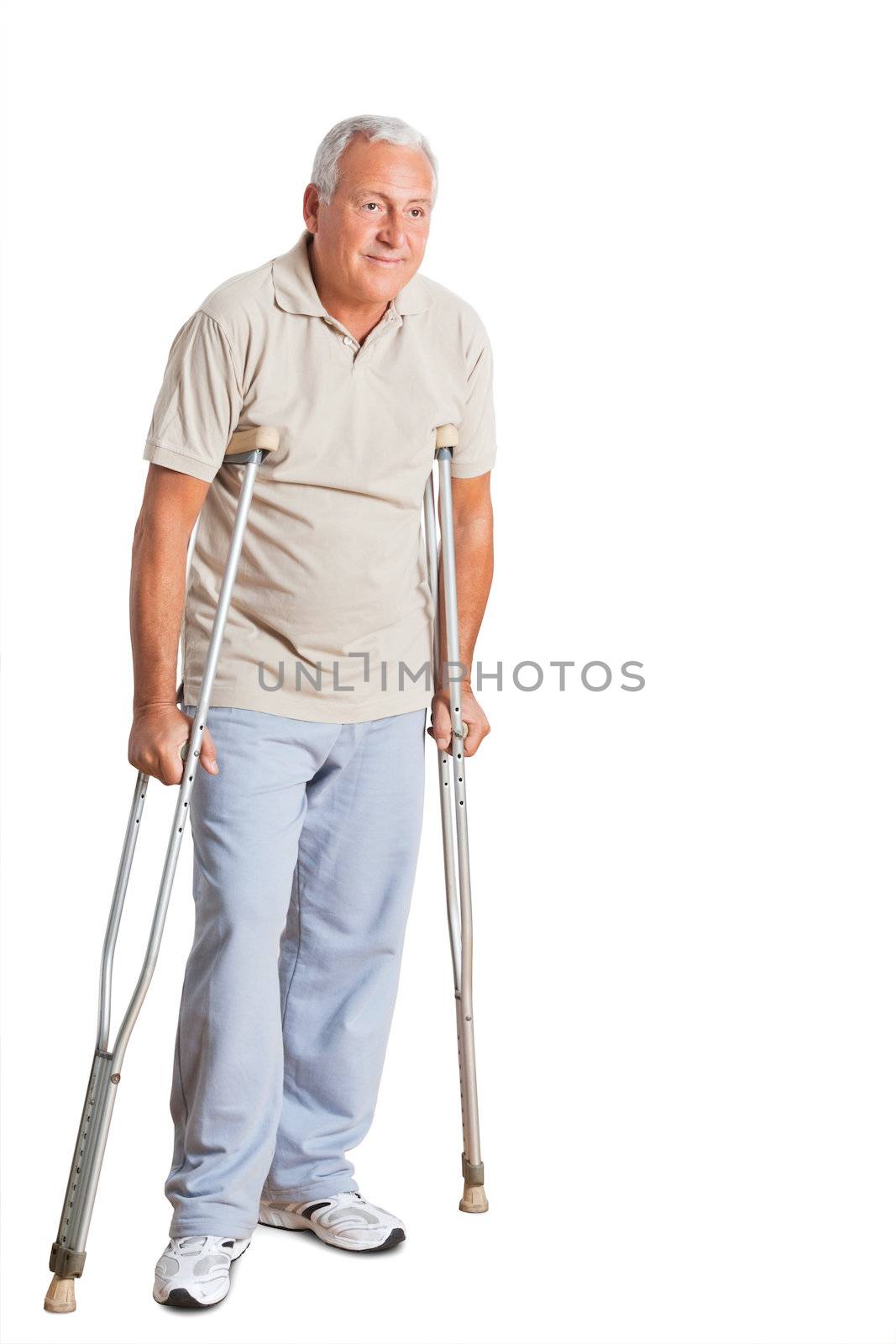 Full length of a senior man on crutches looking away over white background.
