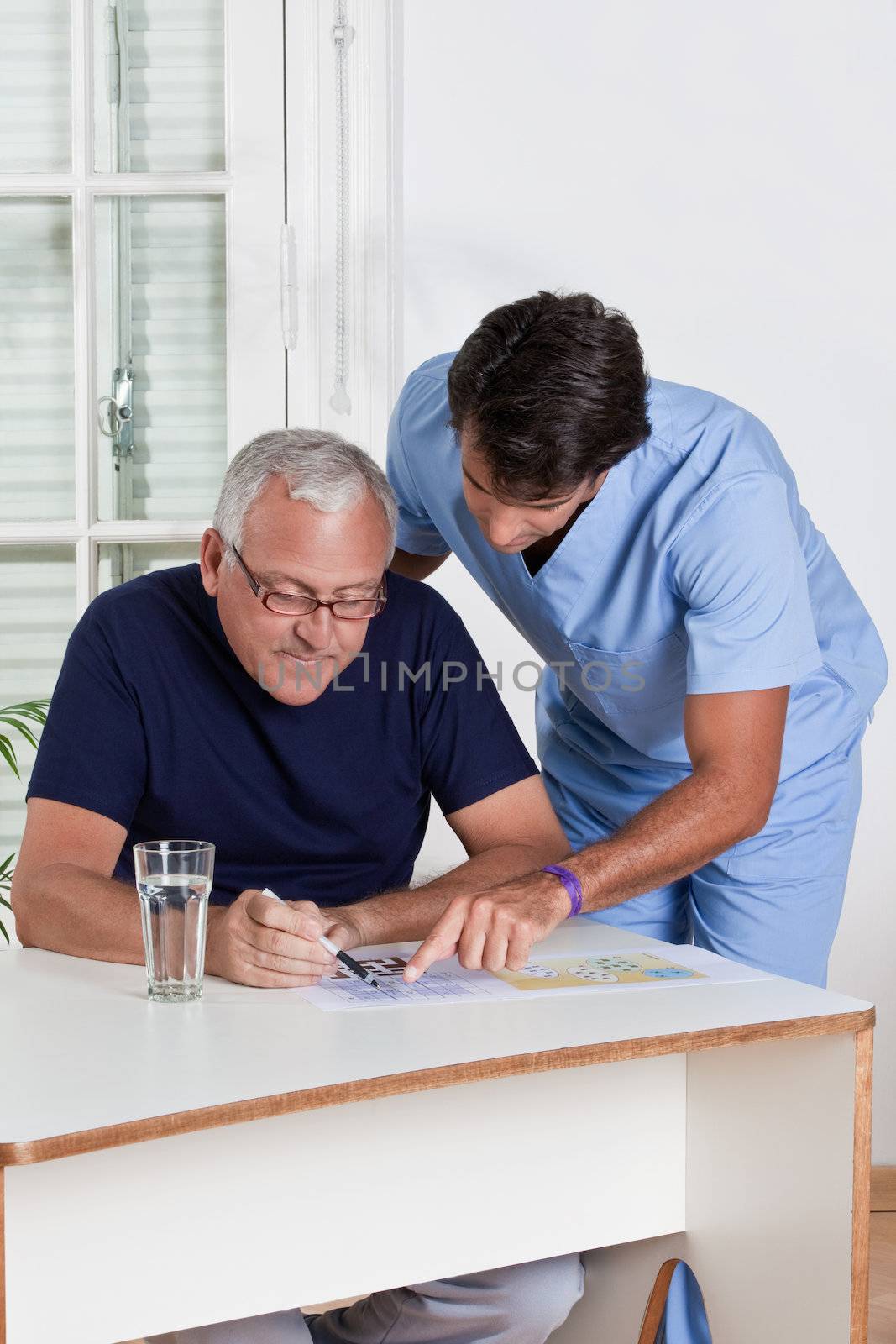 Mature Man playing Sudoku Puzzle by leaf