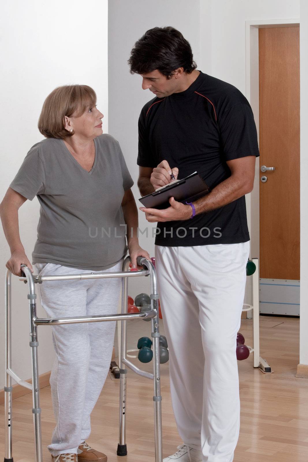 Patient with walker discusses his progress.