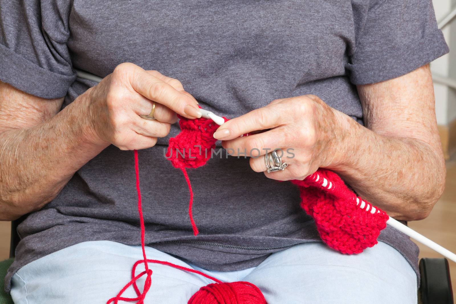 Mid section of senior woman knitting