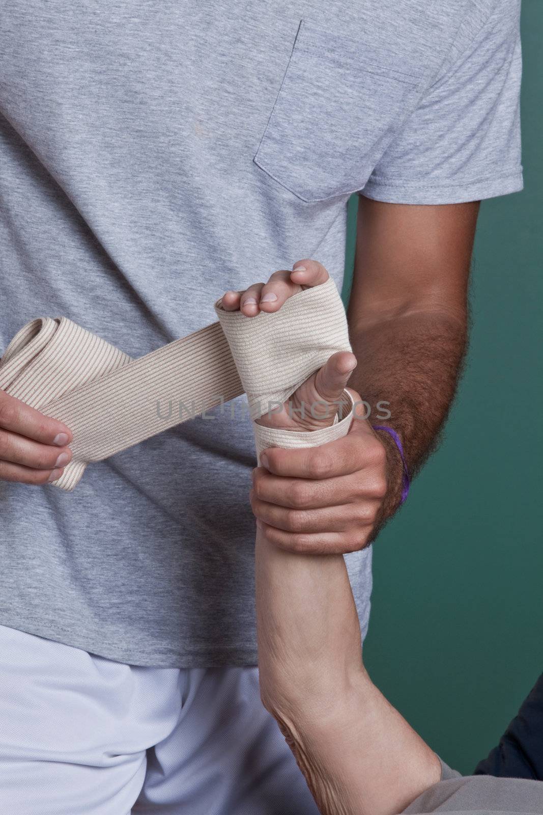 Therapist applying Bandage on the Hand by leaf