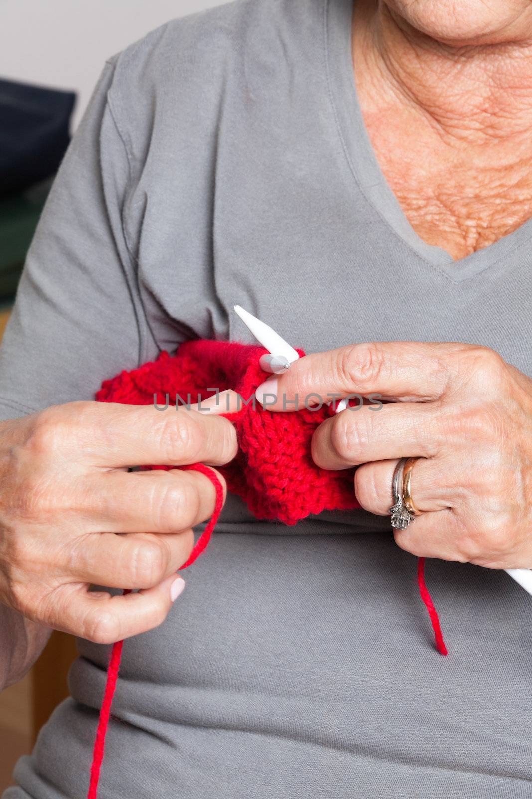 Mid section of senior woman knitting