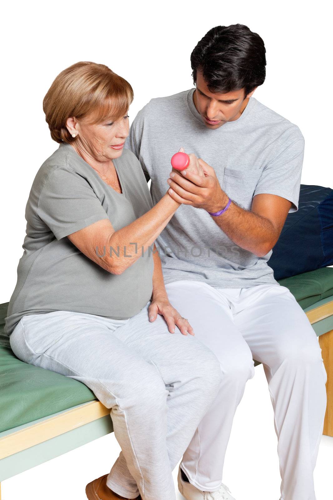 Young therapist giving muscle training for elbow joint over white background