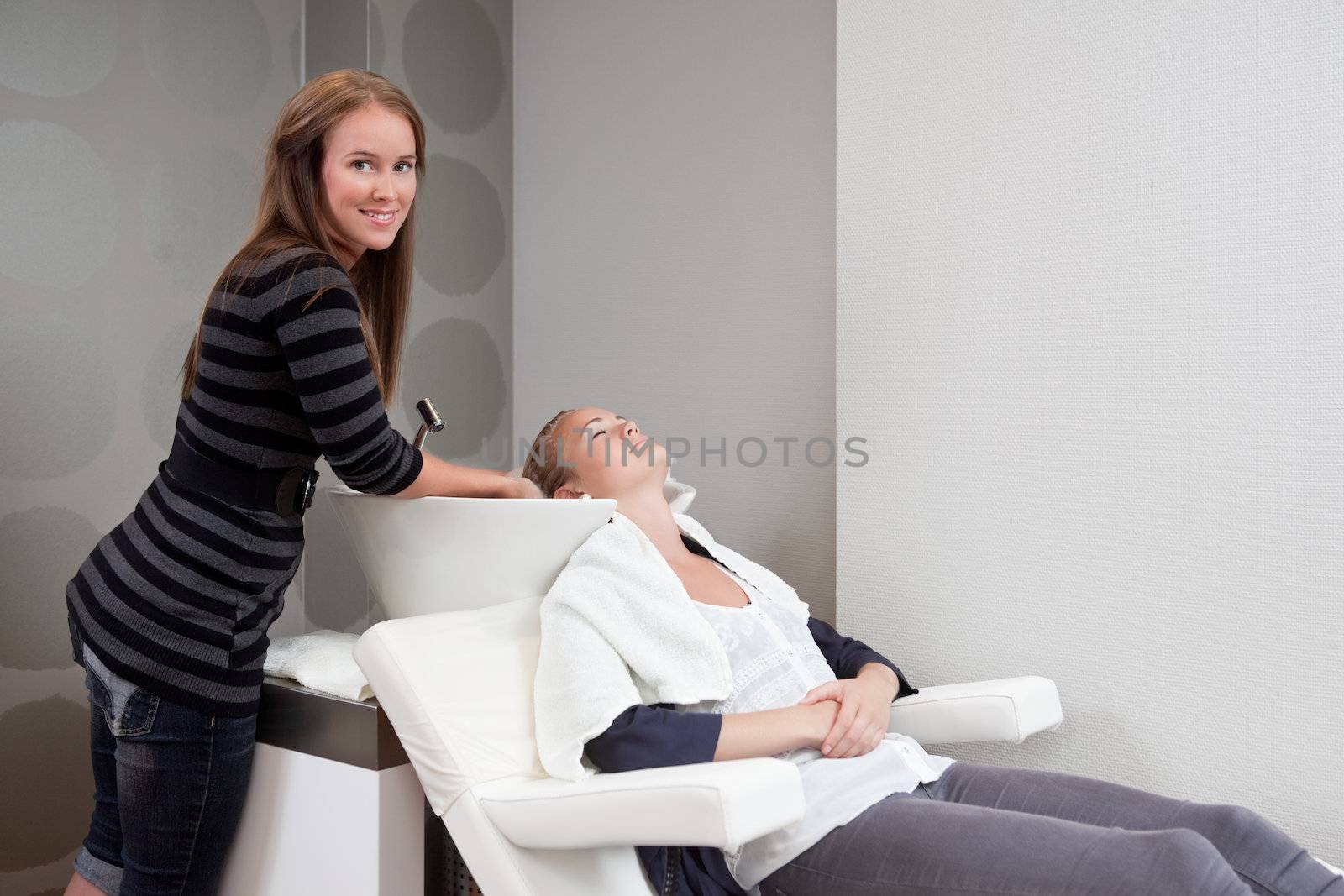 Woman Receiving Hair Wash at Beauty Salon by leaf