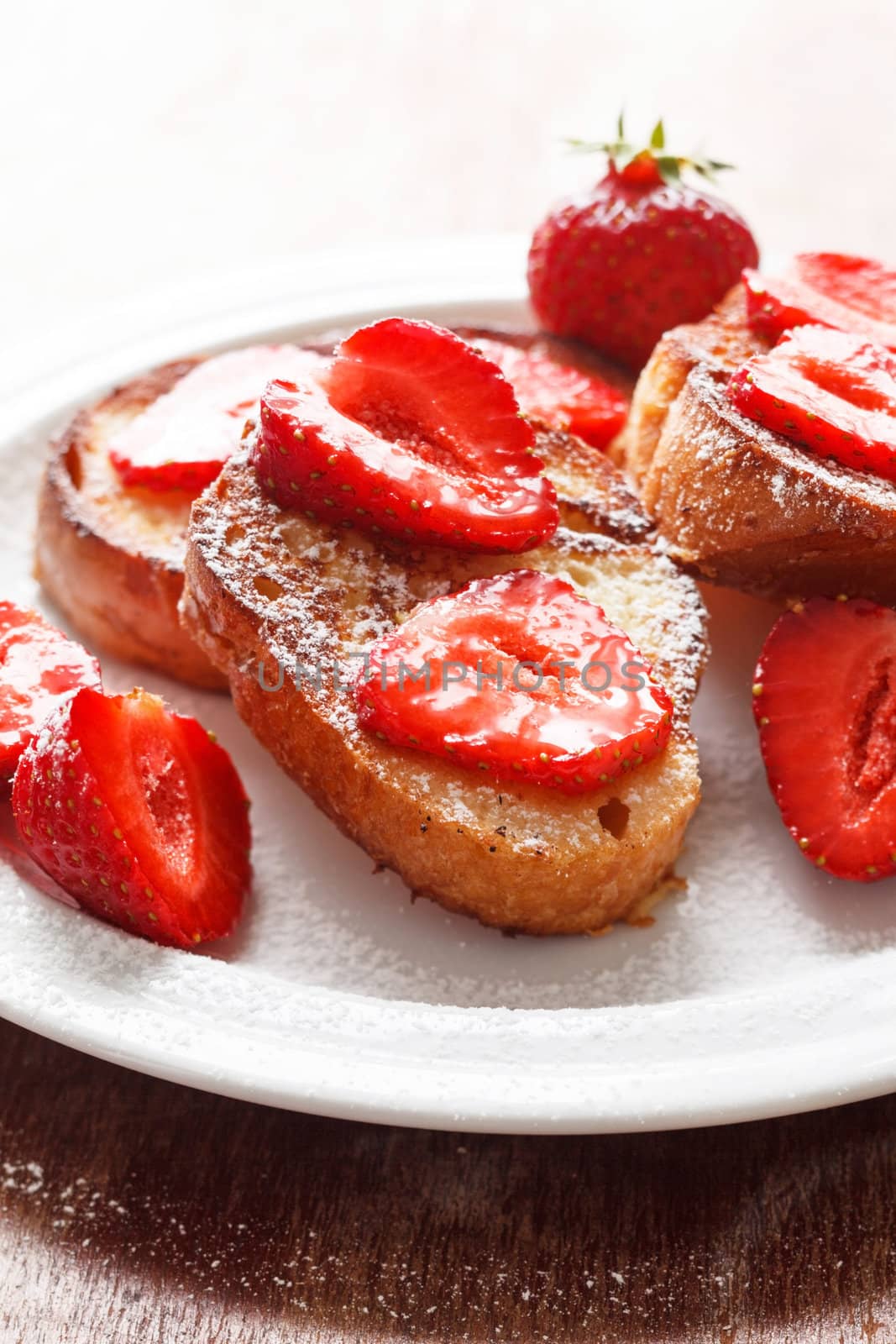 French toasts with powdered sugar and a strawberry