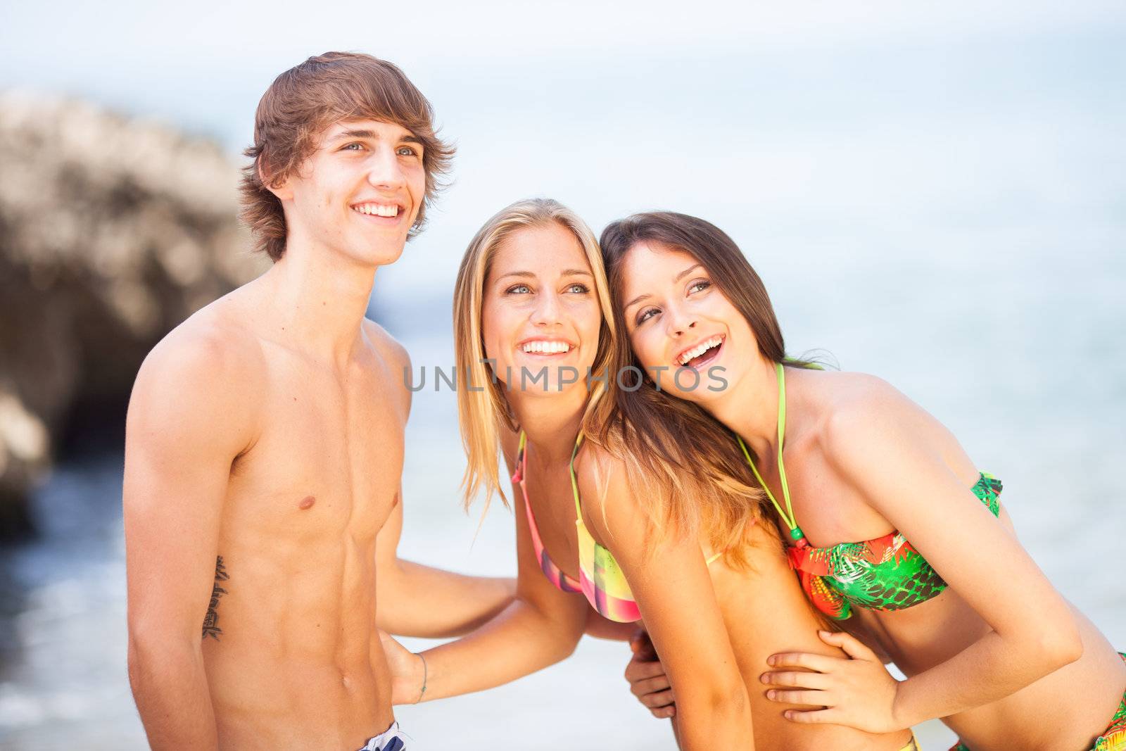 three young beautiful friends having fun on the beach by Lcrespi