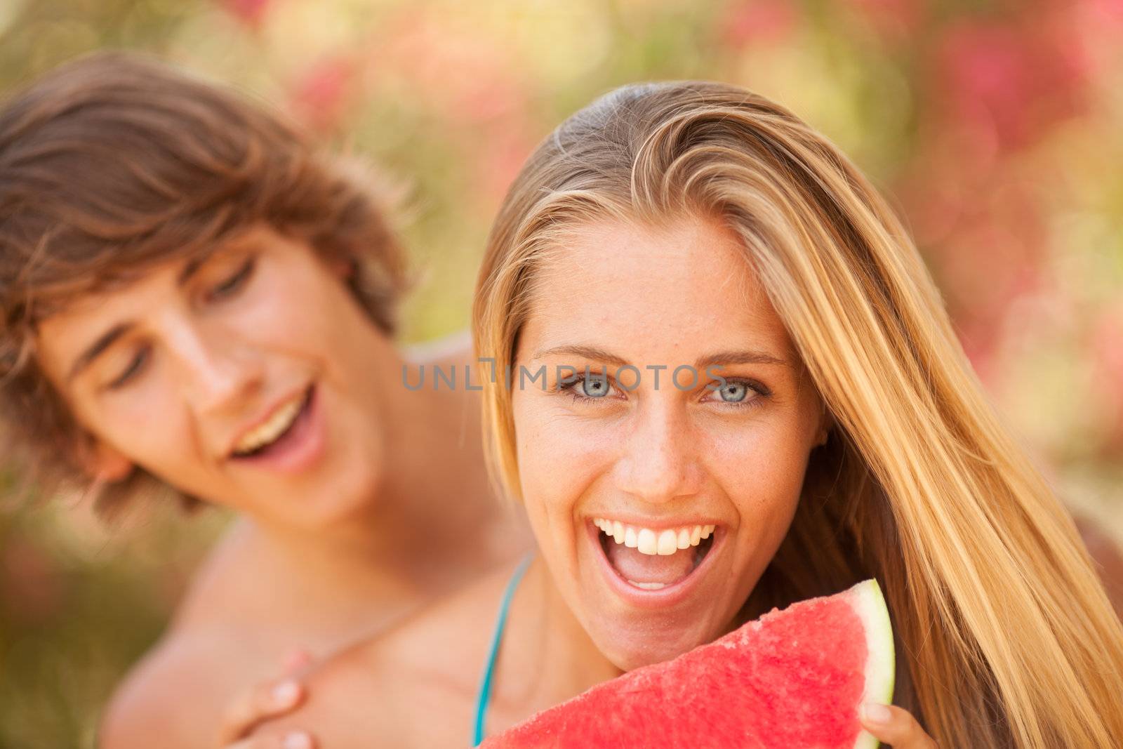 Portrait of a young beautiful couple eating watermelon by Lcrespi