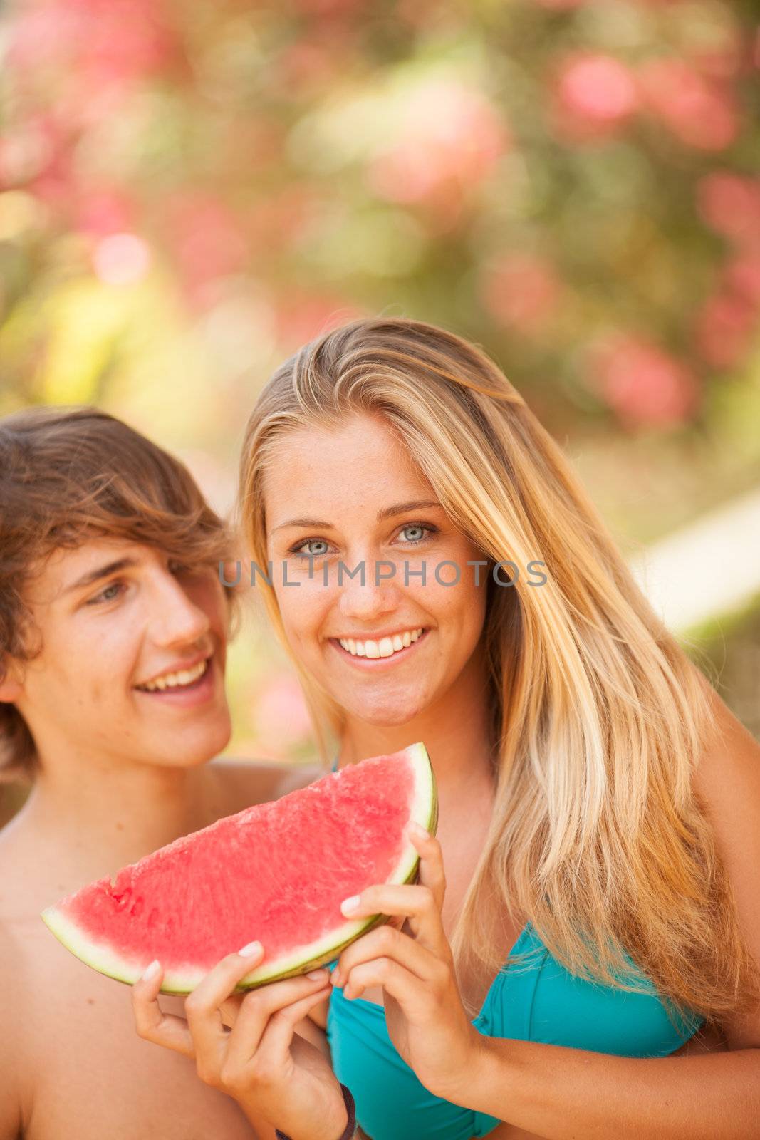 Portrait of a young beautiful couple eating watermelon