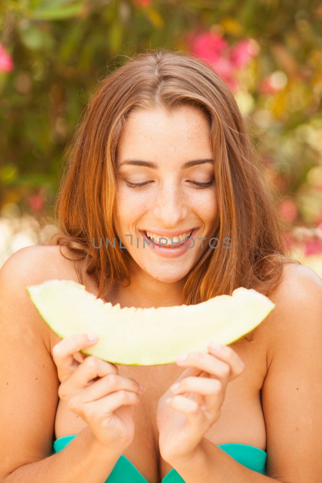 Portrait of a beautiful young woman eating melon by Lcrespi