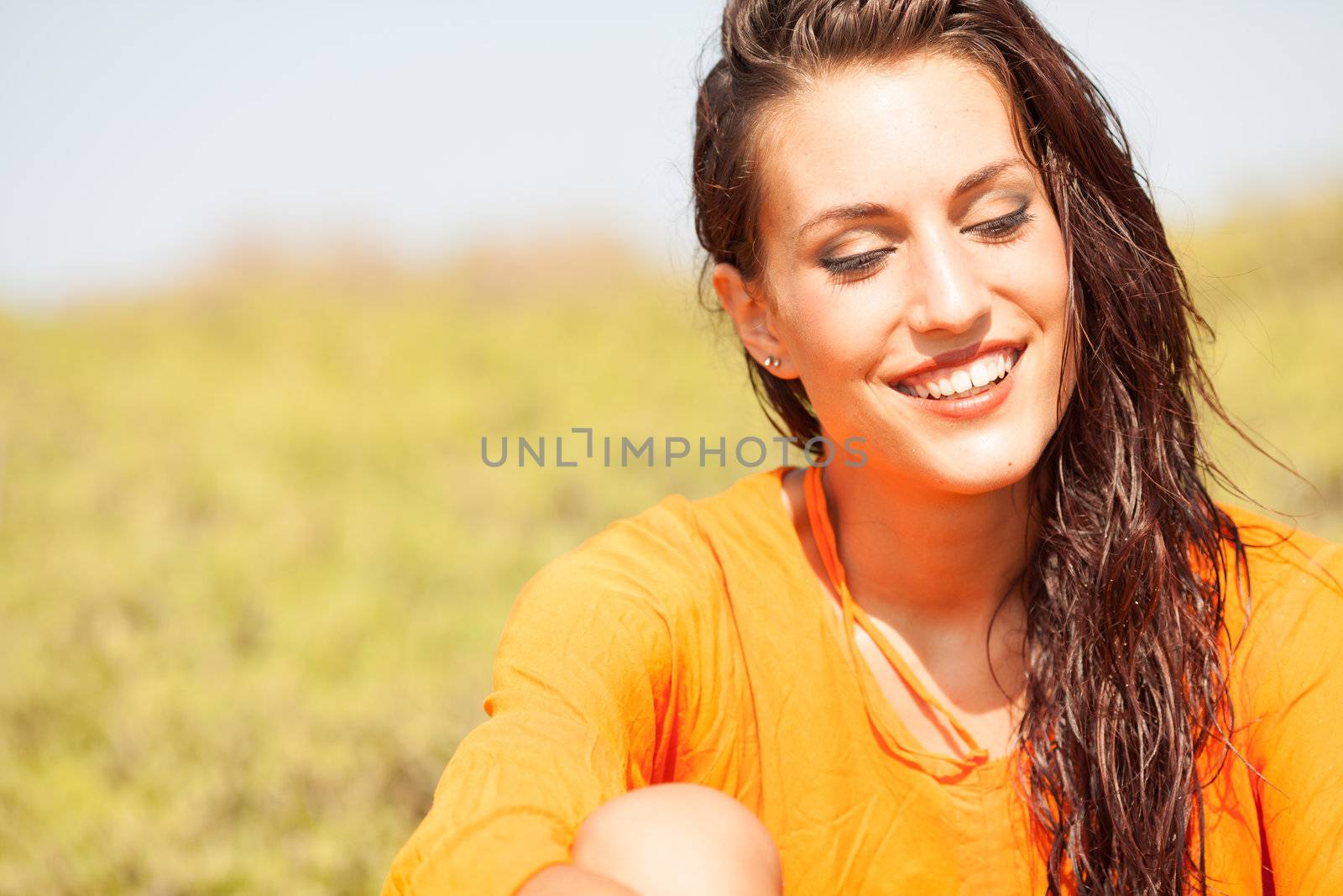 Portrait of young beautiful woman laughing wearing orange shirt by Lcrespi