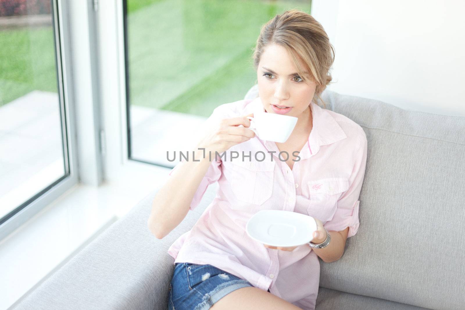 young beautiful woman drinking coffee or tea