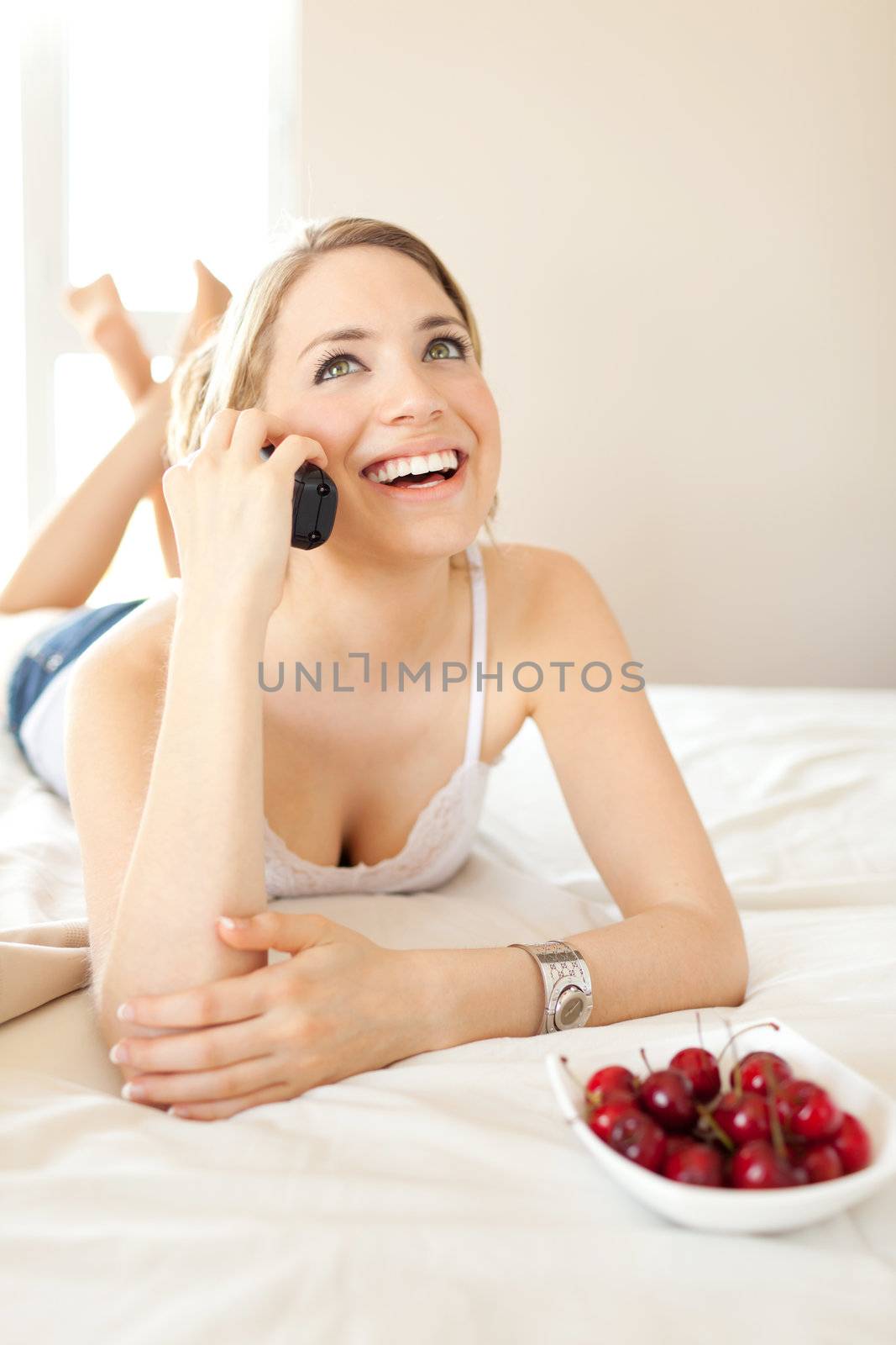 beautiful women having a happy conversation on bed with cherries by Lcrespi