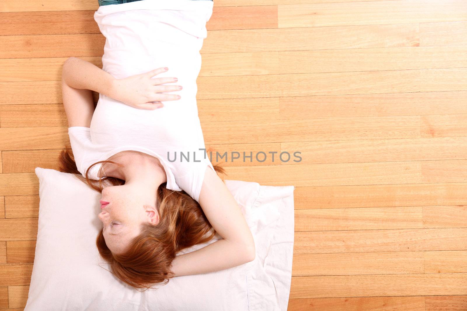 A young adult Woman sleeping on the floor.