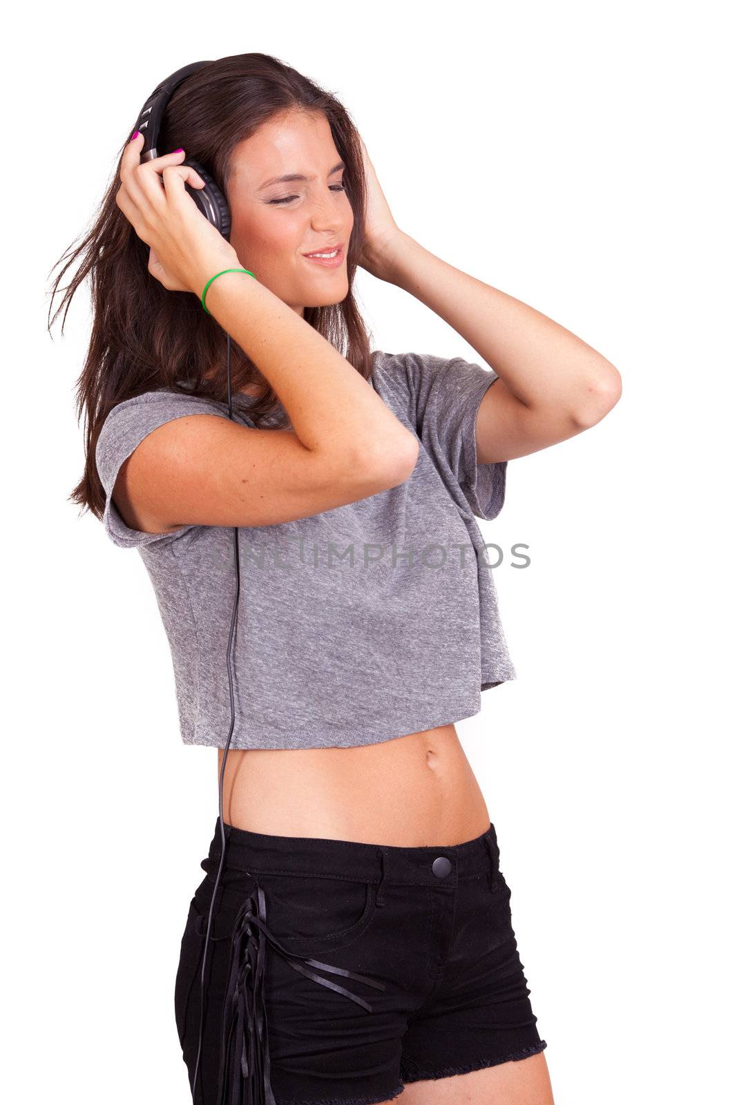 young beautiful women listening music on headphones, on white background, while laughing