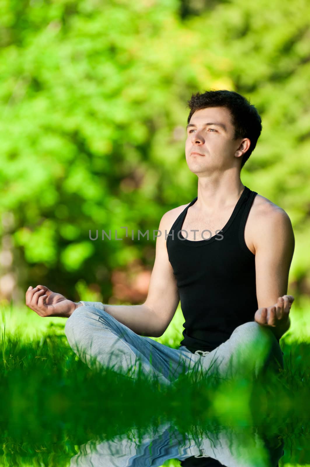 A young man doing yoga exercise by markin