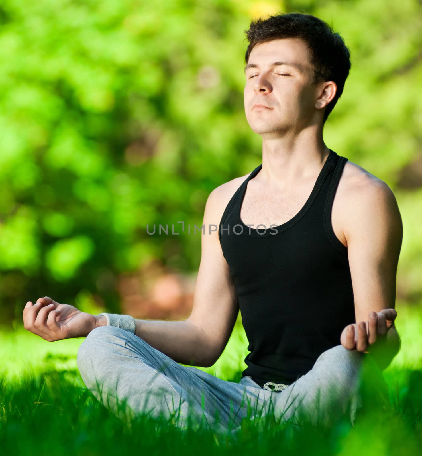 A young man doing yoga exercise by markin