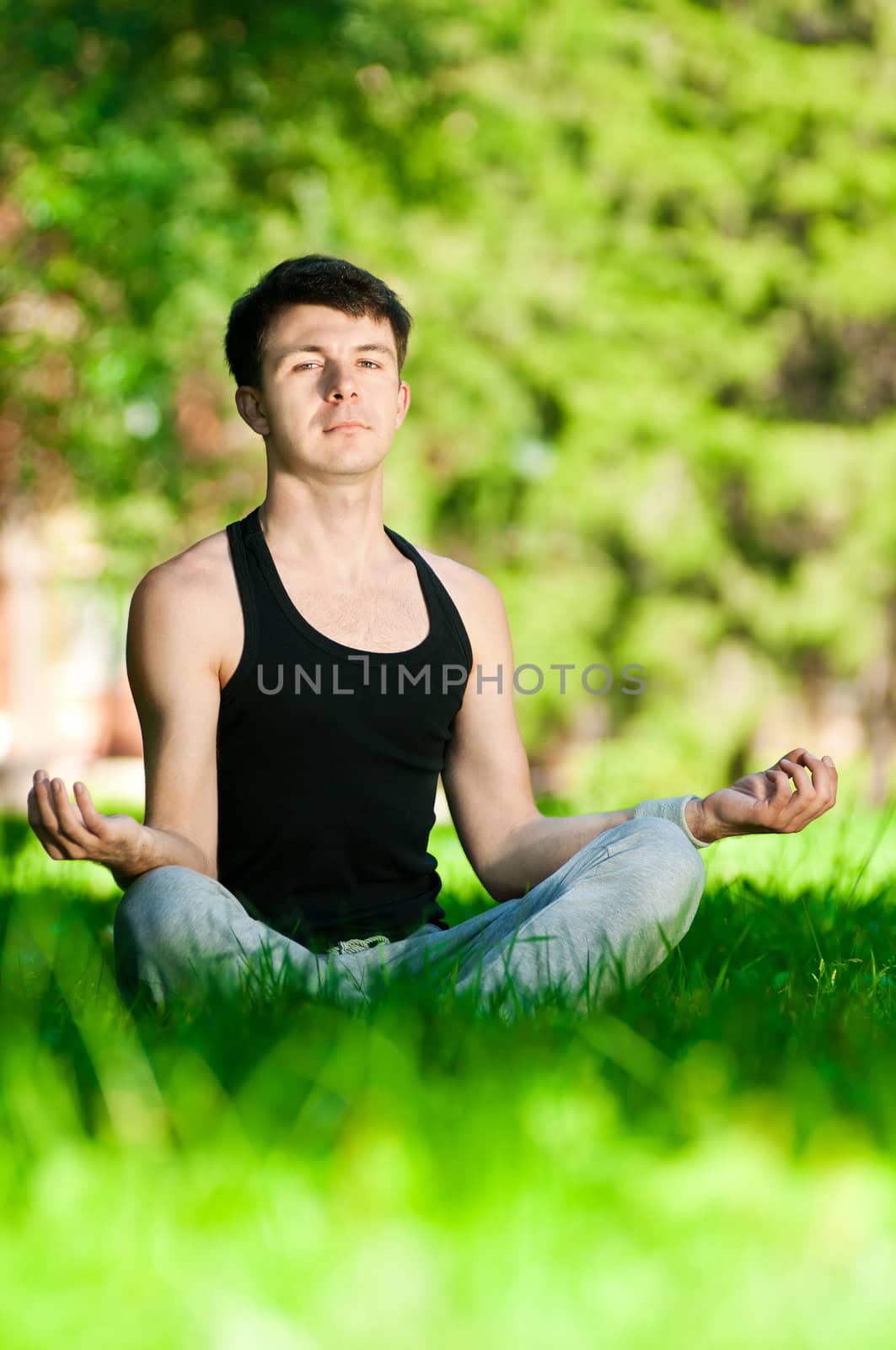 A young man doing yoga exercise by markin