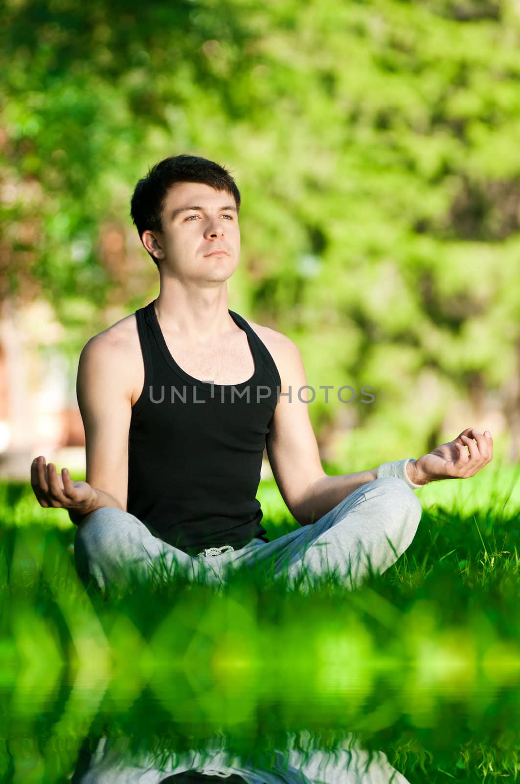 A young man doing yoga exercise by markin