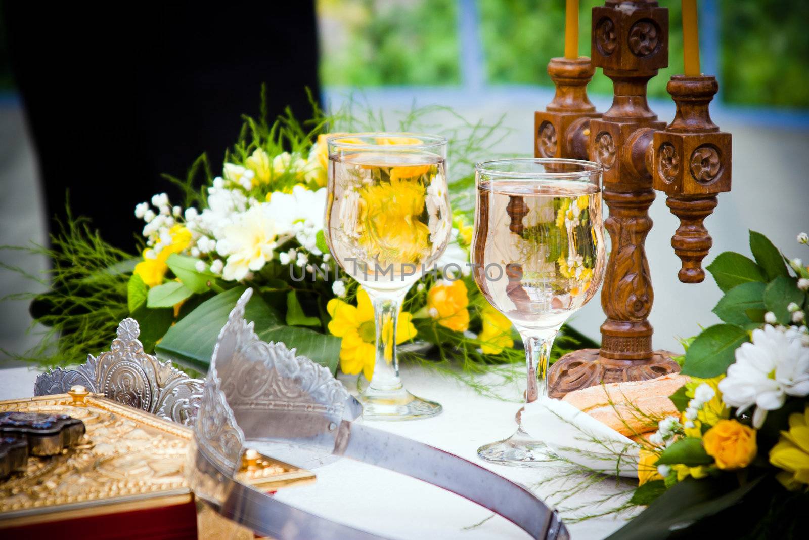 Wedding crowns, bible and wine glasses prepared for ceremony