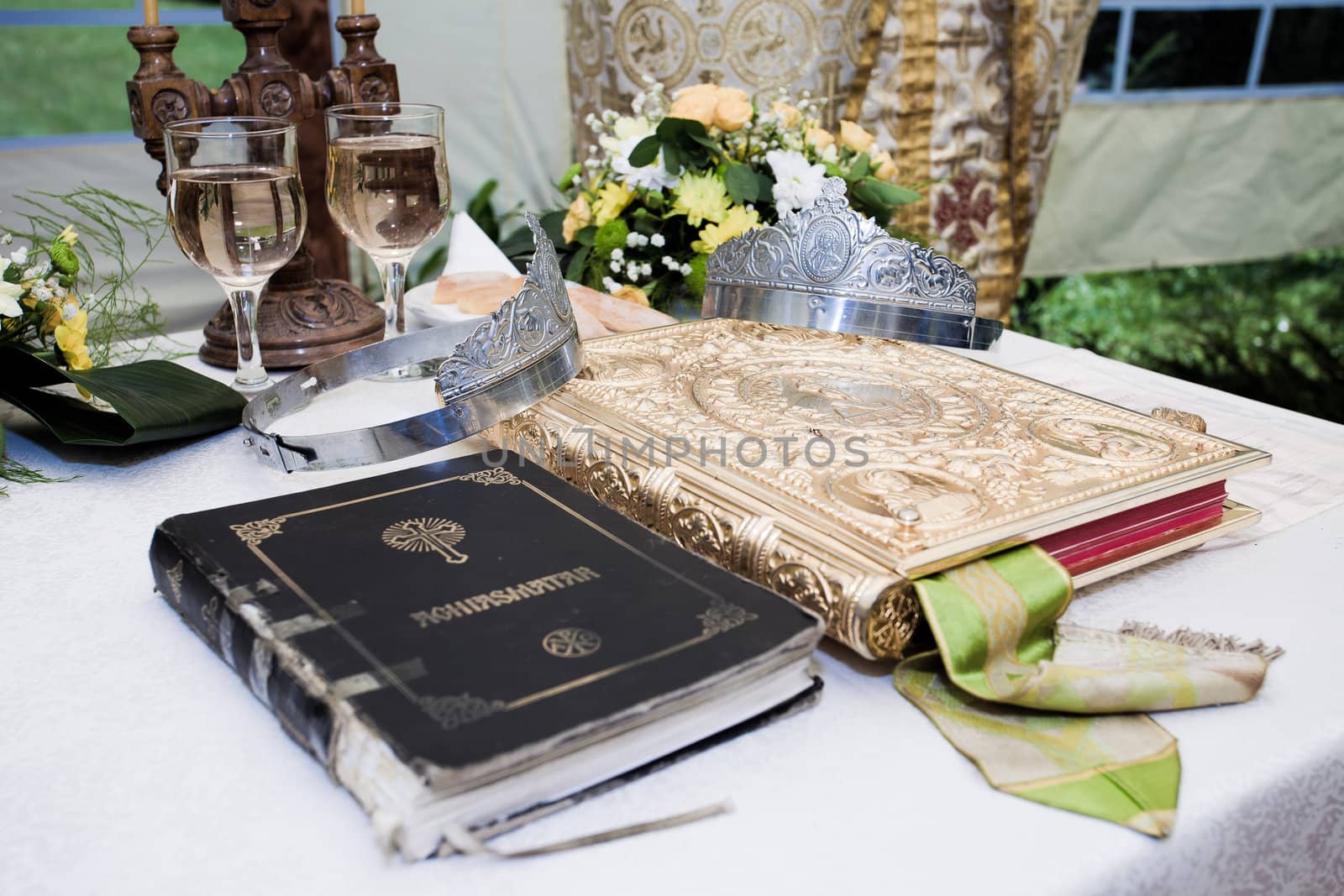 Wedding crowns, bible and wine glasses prepared for ceremony