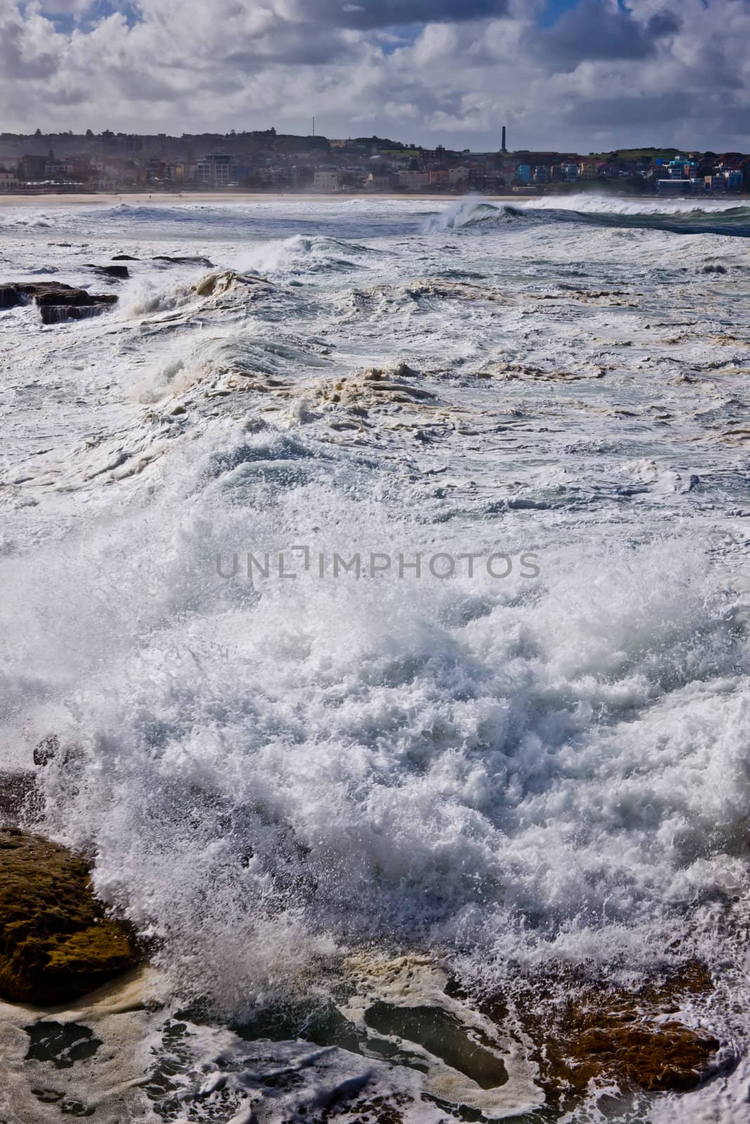 Turbulent waves and white surf at Bondi Beach in Sydney, Australia, crashing ashore during a cyclone