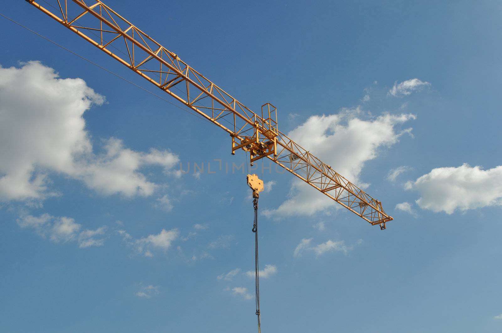 Building crane in a construction site over blue sky