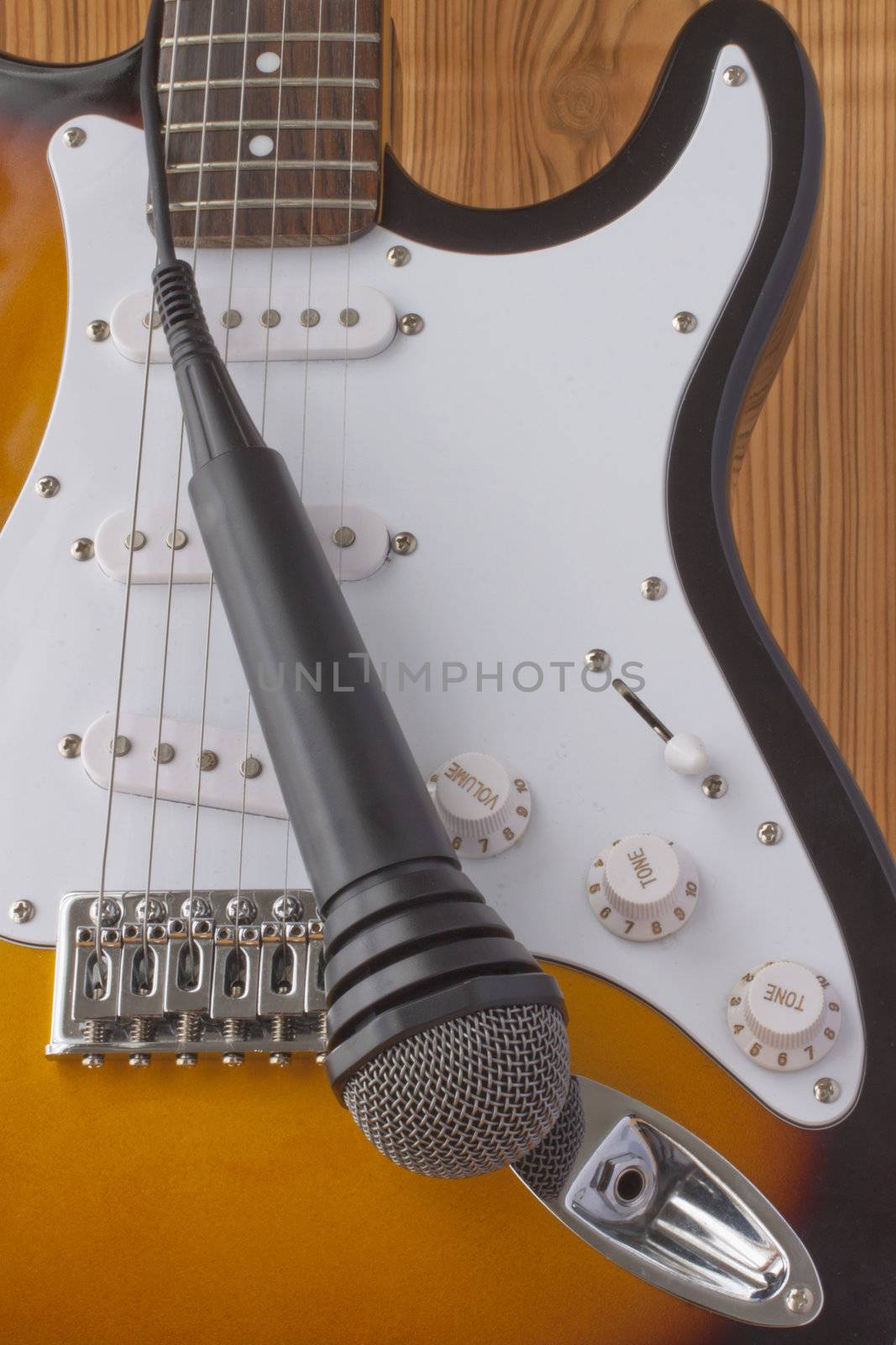 Electric guitar with microphone, over a wooden background