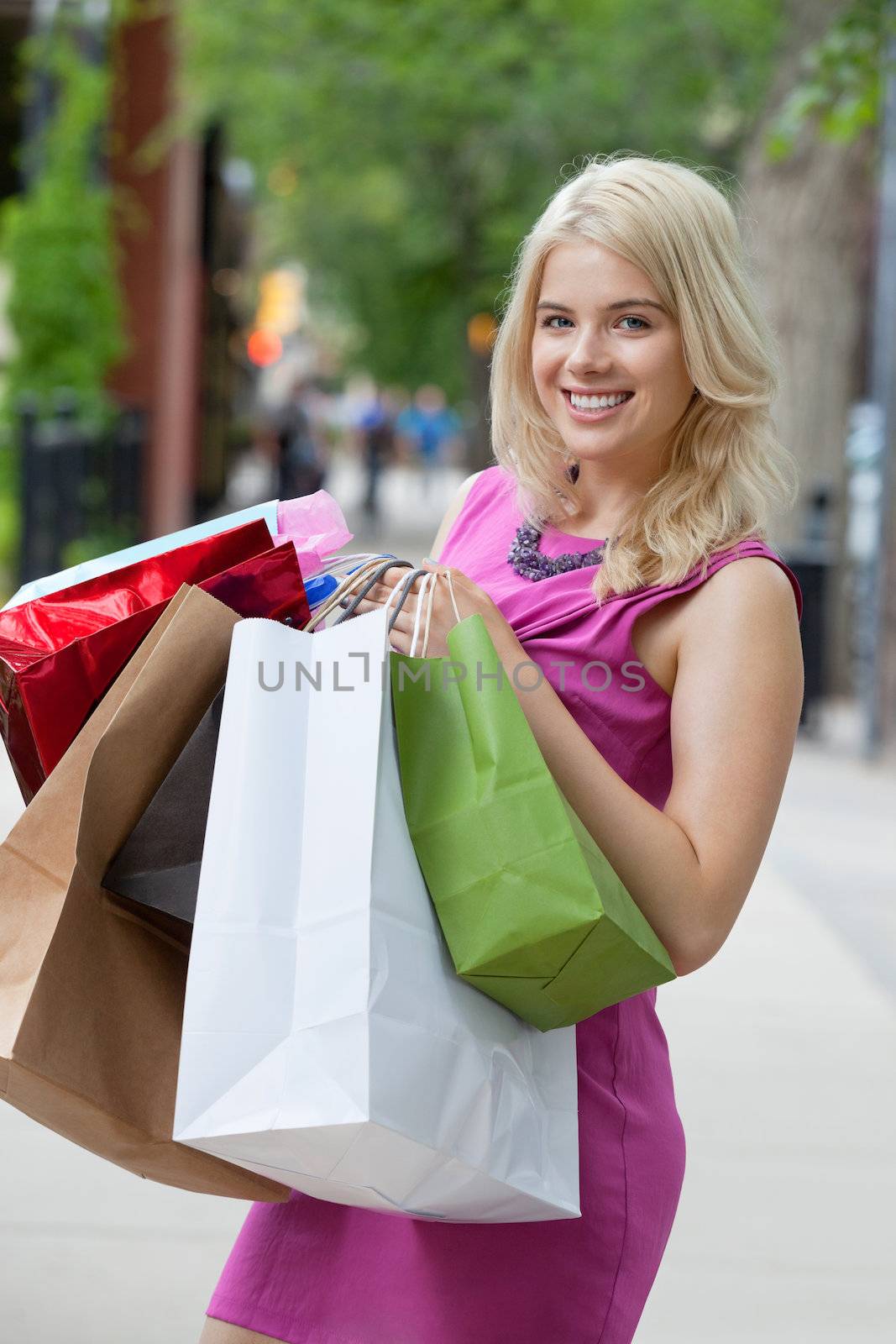 Portrait of a happy young woman carrying shopping bags