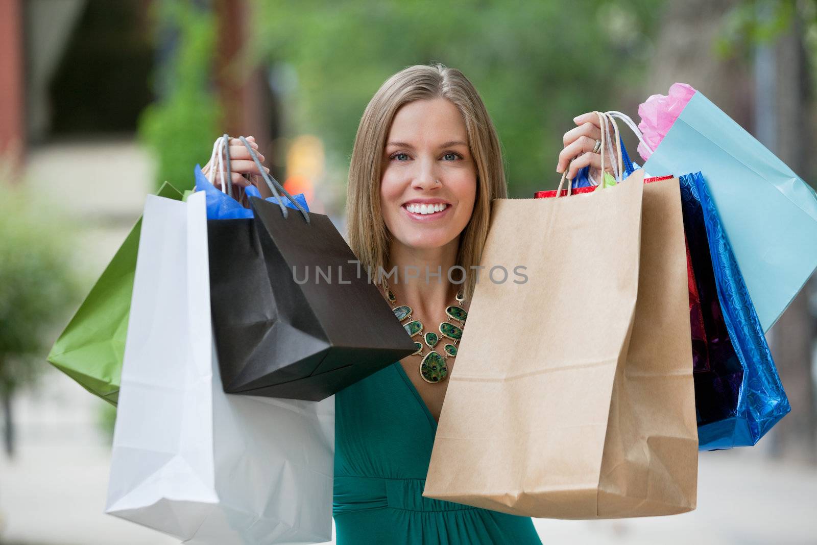 Portrait of happy young woman holding up shopping bags